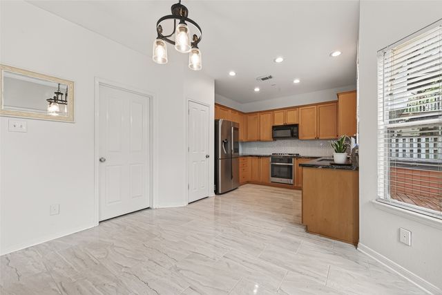 a large kitchen with kitchen island a sink stainless steel appliances and cabinets