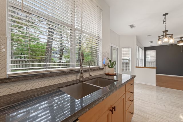a kitchen with granite countertop a sink and a white wooden cabinets