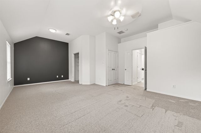 a view of an empty room with a chandelier fan
