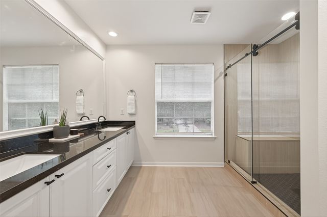 a large bathroom with a granite countertop sink a toilet and a shower