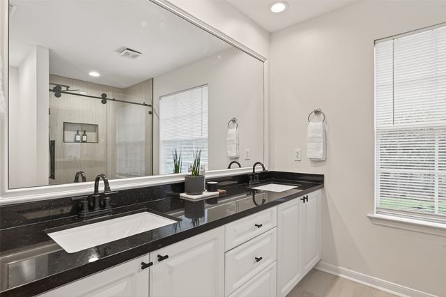 a bathroom with double sink and a mirror