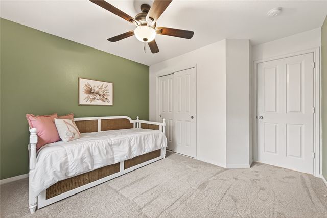 a spacious bedroom with a bed and a ceiling fan