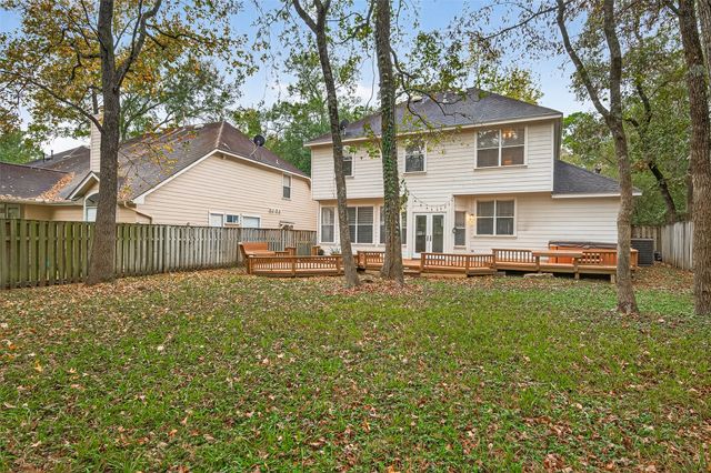 a view of a house with backyard and a tree