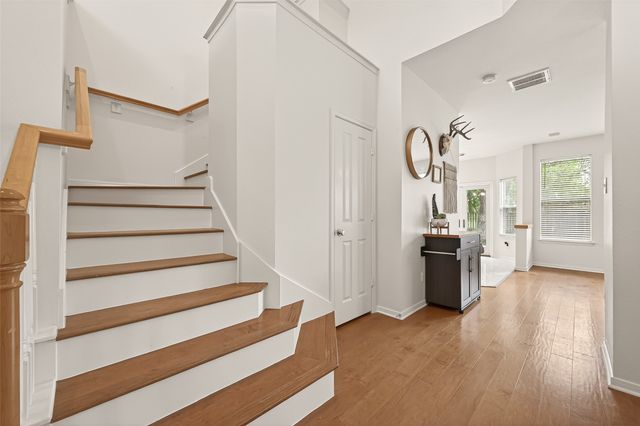 a view of a livingroom with wooden floor and stairs