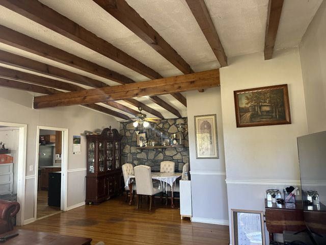 a dining room with wooden floor table and chairs