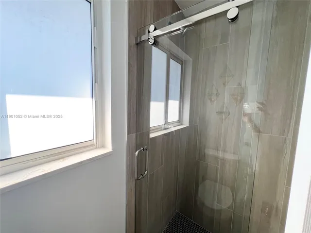 a view of an empty room with closet and a window