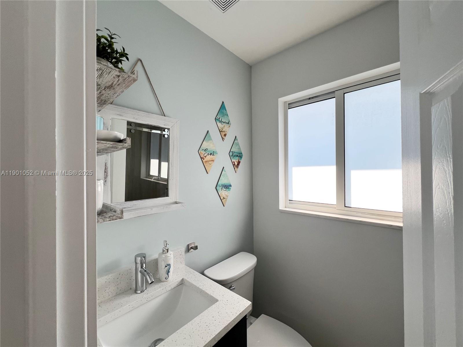 312 Elm Street Hollywood, FL 33019 - Photo 23 of 52 a bathroom with a sink mirror and a window