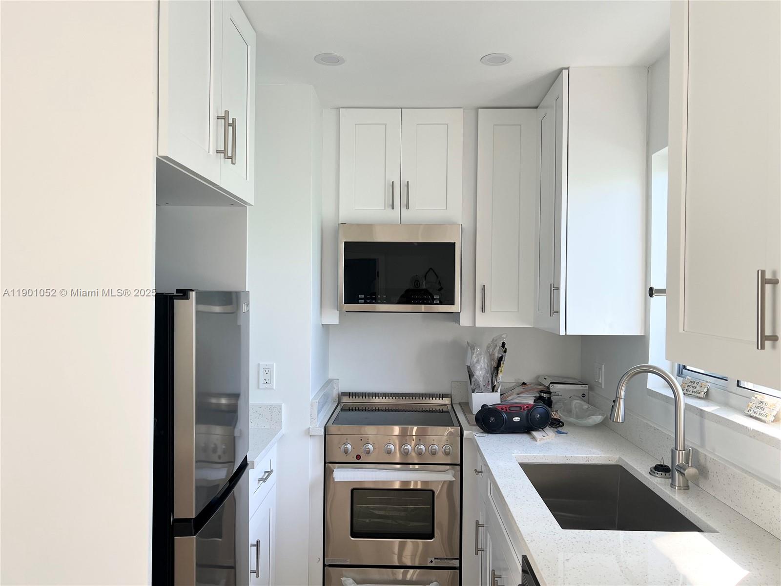 312 Elm Street Hollywood, FL 33019 - Photo 29 of 52 a kitchen with a sink a stove and cabinets