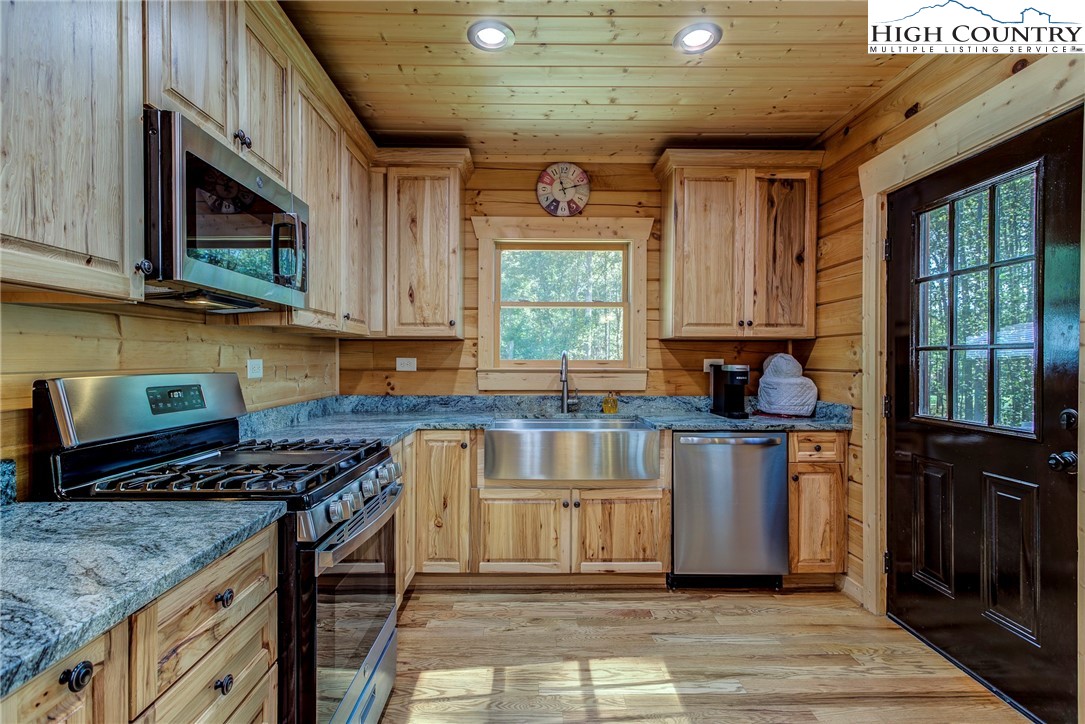 3460 South Center Church Road Thurmond, NC 28683 - Photo 21 of 50 a kitchen with stainless steel appliances granite countertop a stove a sink and a microwave