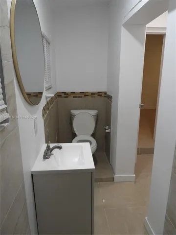 an empty room with wooden floor and cabinet