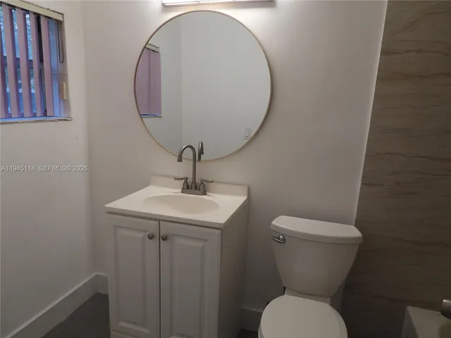 a bathroom with a toilet a sink and a mirror