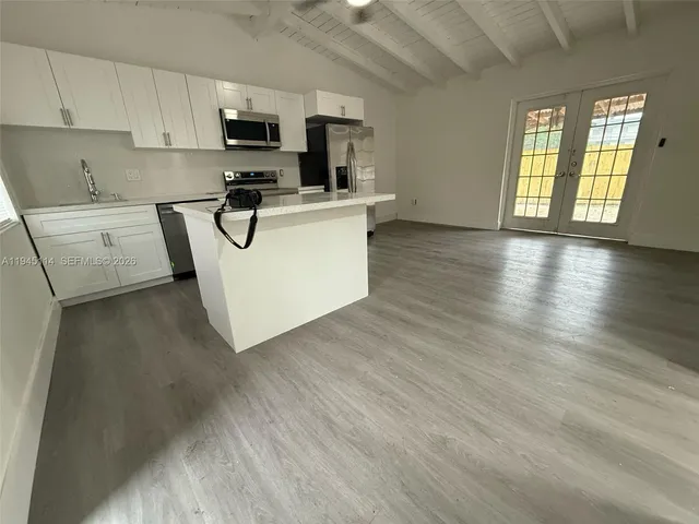 a view of a hallway with closet and a bathroom