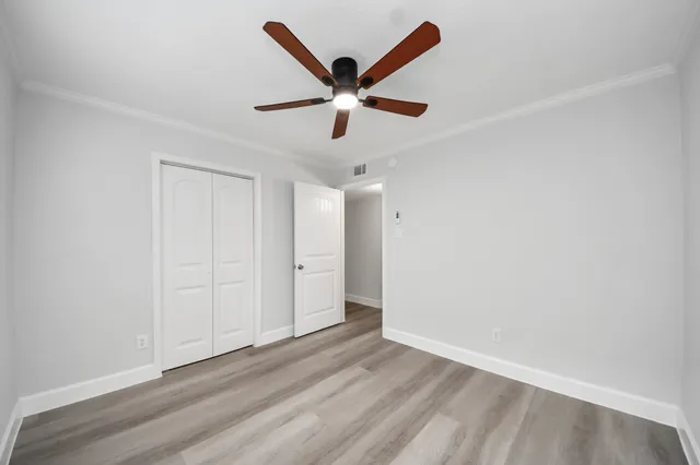 a view of empty room with wooden floor and window