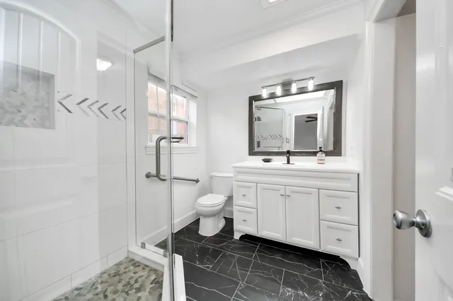 a bathroom with a sink a toilet and shower