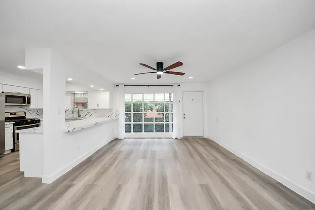 a view of a kitchen with microwave and windows