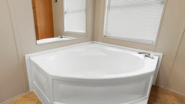 a white bath tub sitting in a bathroom next to a window