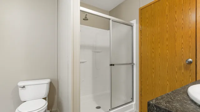 a bathroom with a toilet and a shower