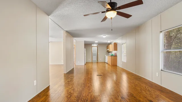 a view of an empty room and kitchen view