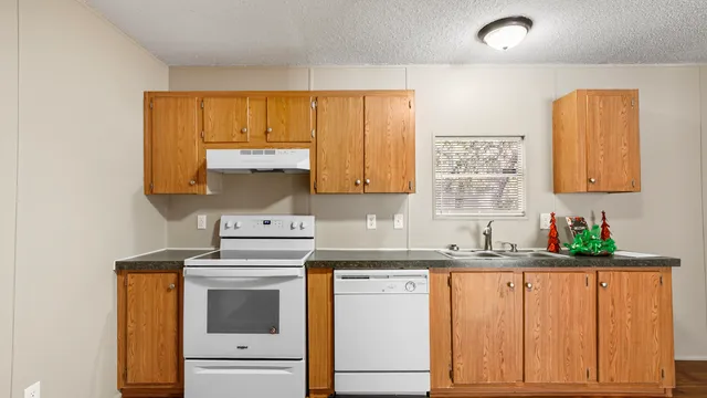 a kitchen with granite countertop a sink stainless steel appliances and cabinets