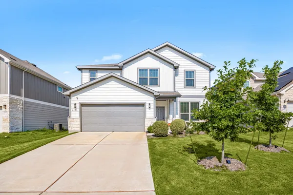 a front view of a house with a yard and garage