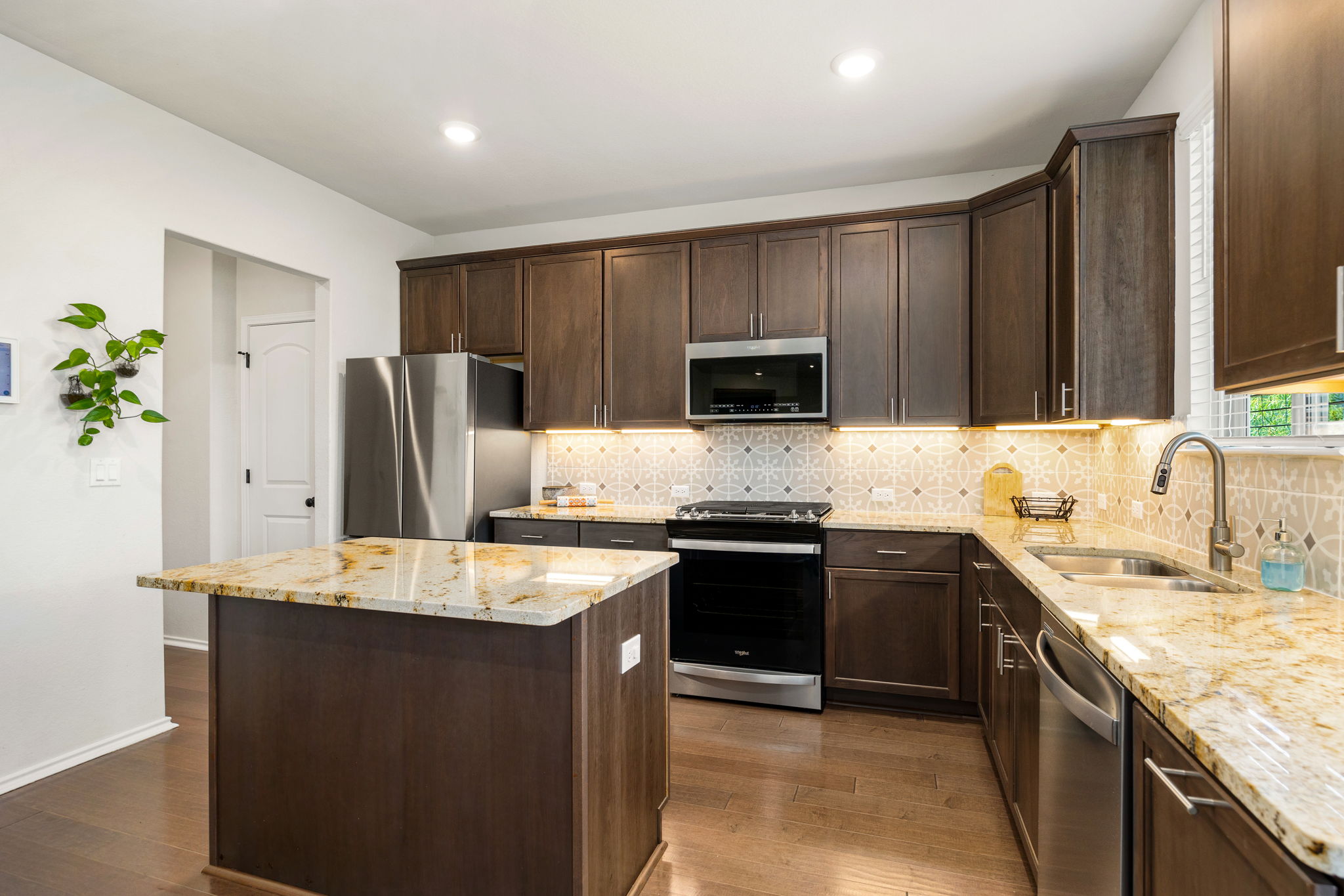 6808 Ellsworth Walk Austin, TX 78724 - Photo 11 of 40 a kitchen with kitchen island granite countertop appliances cabinets and counter space