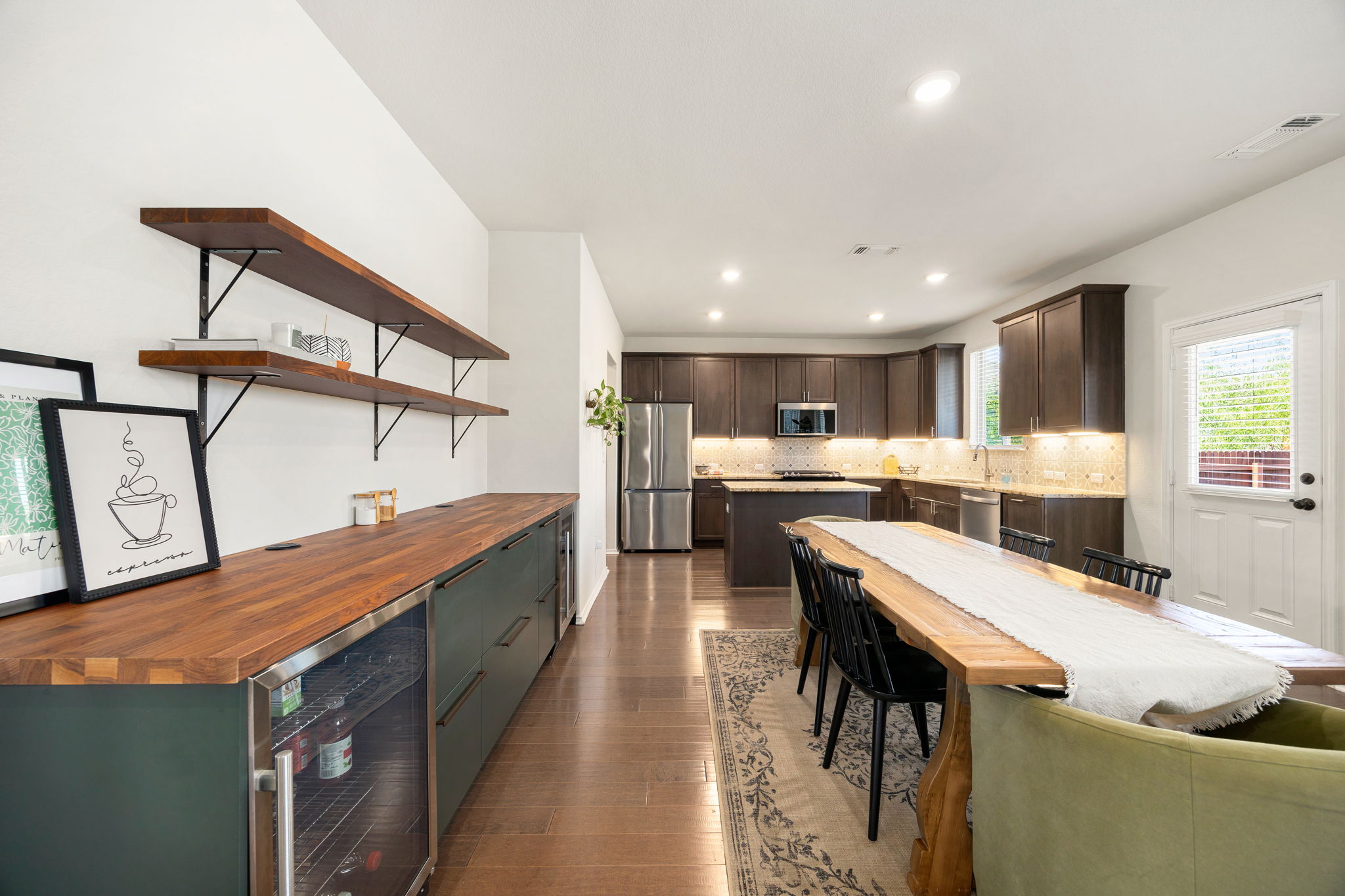 6808 Ellsworth Walk Austin, TX 78724 - Photo 14 of 40 a large kitchen with kitchen island a stove a sink a dining table and chairs