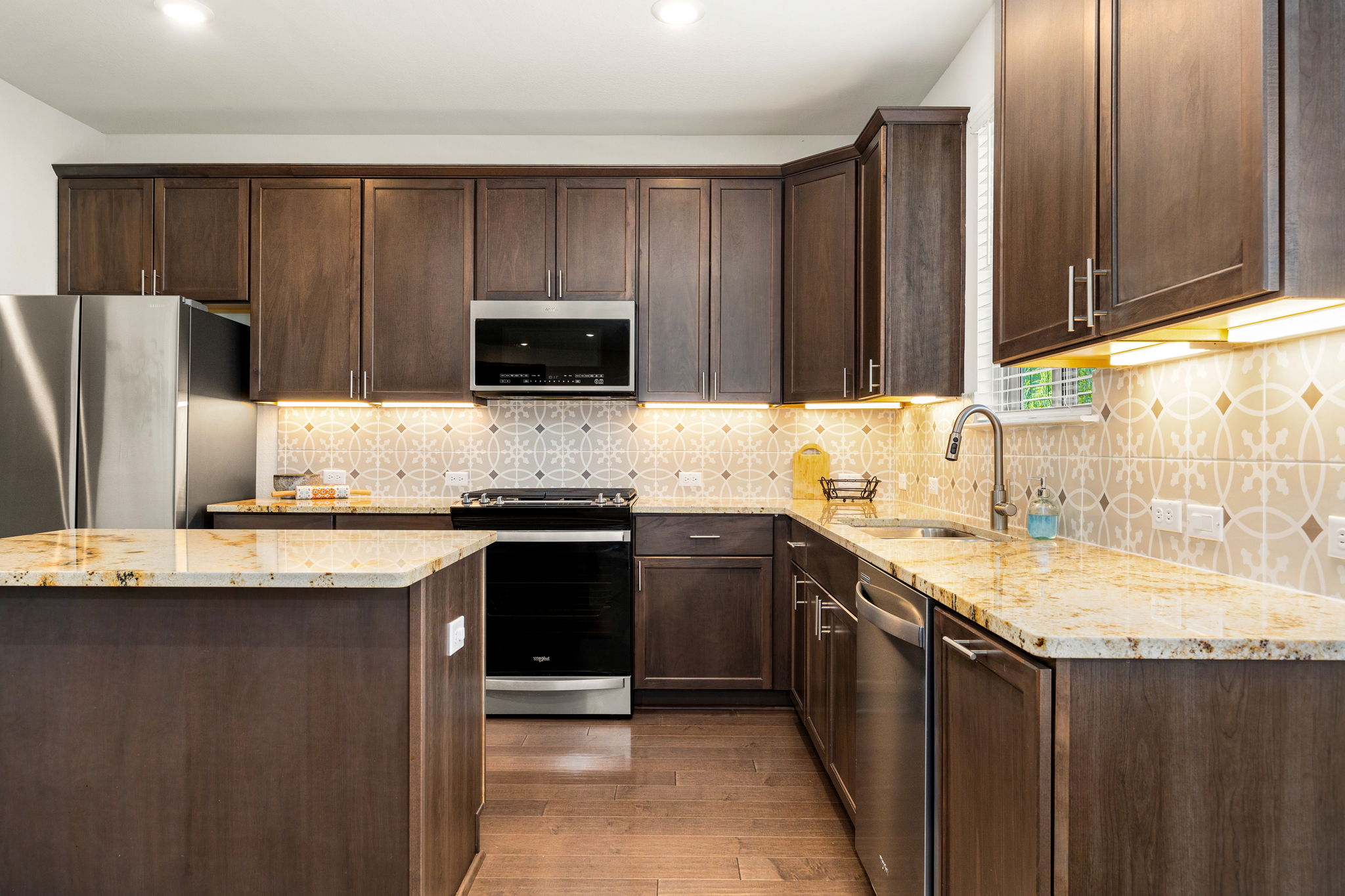 6808 Ellsworth Walk Austin, TX 78724 - Photo 7 of 40 a kitchen with granite countertop a refrigerator stove and sink