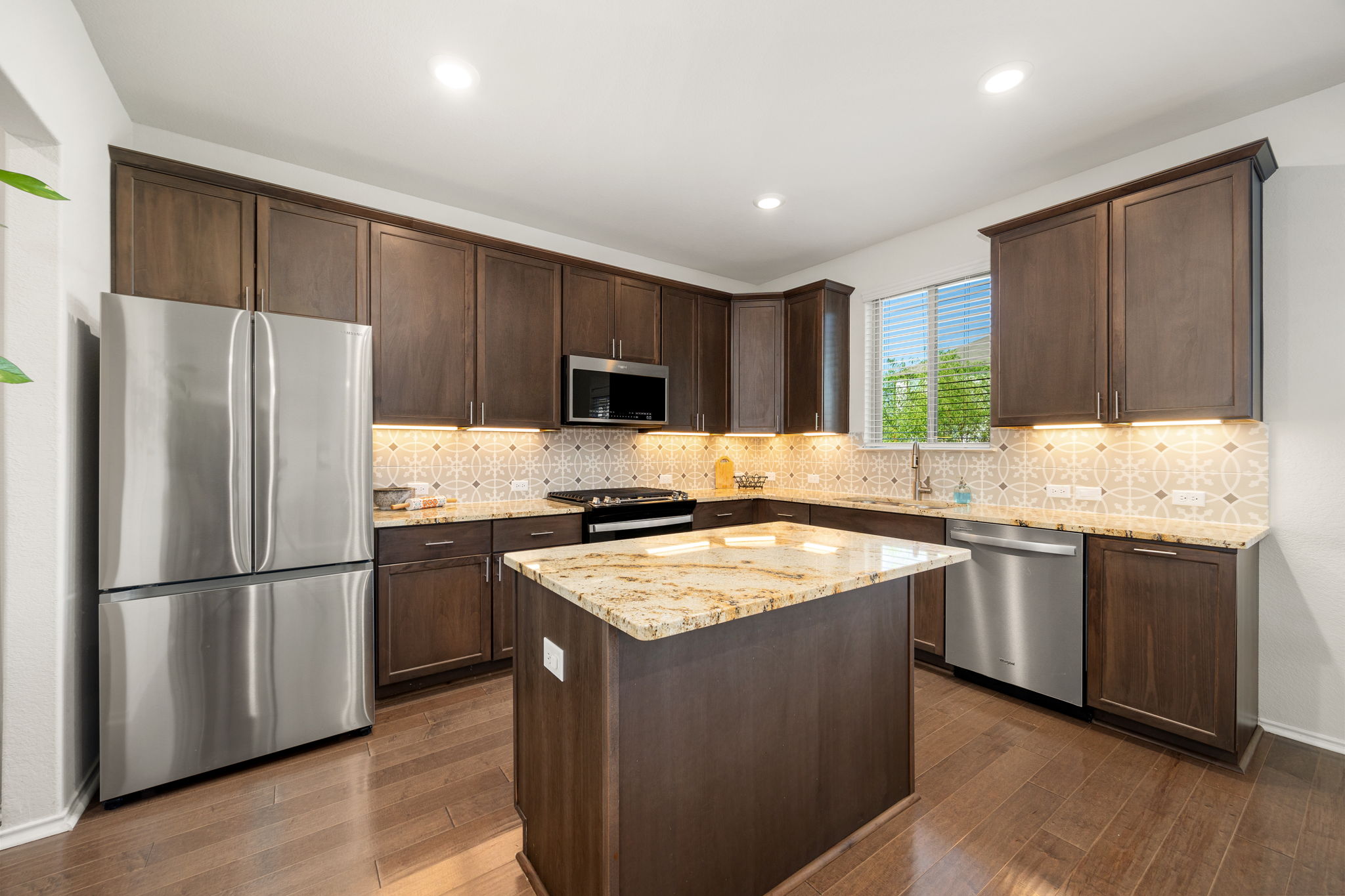 6808 Ellsworth Walk Austin, TX 78724 - Photo 9 of 40 a kitchen with stainless steel appliances granite countertop a refrigerator a sink dishwasher a stove and white cabinets with wooden floor