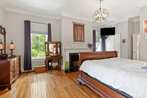 a bedroom with a bed and wooden floor