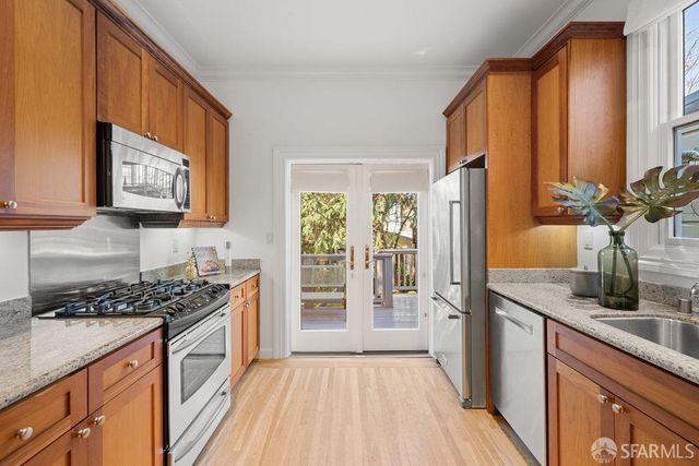 a kitchen with stainless steel appliances a stove a sink and a refrigerator