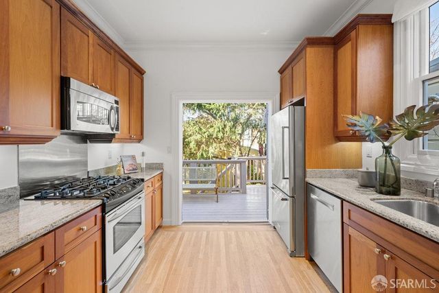 a kitchen with stainless steel appliances a stove a sink and a refrigerator