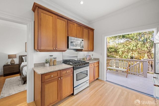 a kitchen with stainless steel appliances granite countertop a stove a sink and a microwave