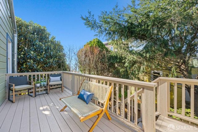 a view of deck with furniture and trees around