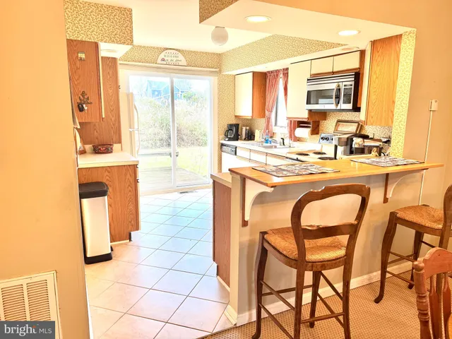 a kitchen with a sink a stove and chairs