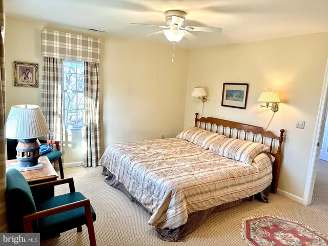 a bedroom with a bed and a lamp next to a window