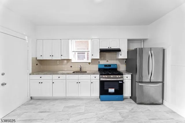 a kitchen with cabinets stainless steel appliances and a window