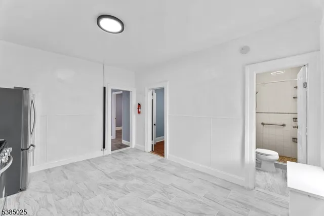 a view of a livingroom with wooden floor and a bathroom