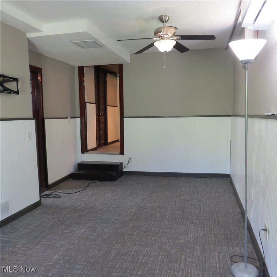 45560 North Ridge Road Amherst, OH 44001 - Photo 31 of 50 Carpeted empty room featuring a wainscoted wall and ceiling fan