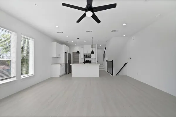 a view of a kitchen with stainless steel appliances a refrigerator and a stove top oven