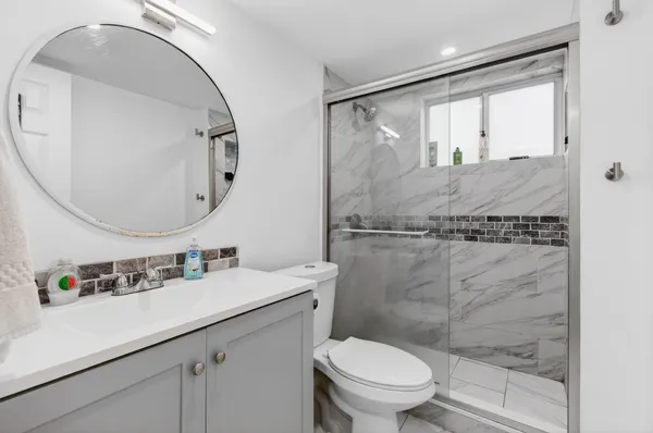 a bathroom with a sink toilet vanity and shower