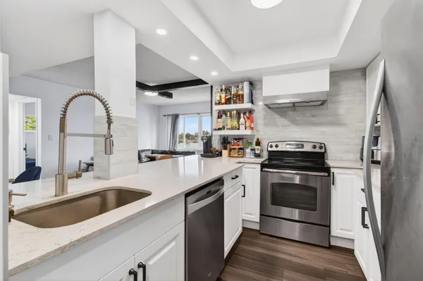 a kitchen with stainless steel appliances granite countertop a stove a sink and a microwave