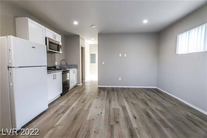 2201 Fairfield Avenue, Unit 21 Las Vegas, NV 89102 - Photo 5 of 7 Kitchen featuring stainless steel appliances, white cabinetry, light wood finished floors, recessed lighting, and baseboards
