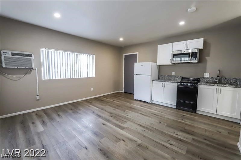 2201 Fairfield Avenue, Unit 21 Las Vegas, NV 89102 - Photo 6 of 7 Kitchen featuring stainless steel microwave, gas stove, freestanding refrigerator, a sink, and stone counters