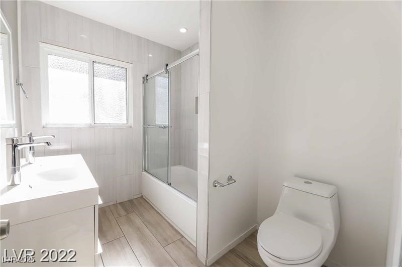 2201 Fairfield Avenue, Unit 21 Las Vegas, NV 89102 - Photo 7 of 7 Full bath with toilet, vanity, wood finished floors, shower / bath combination with glass door, and recessed lighting