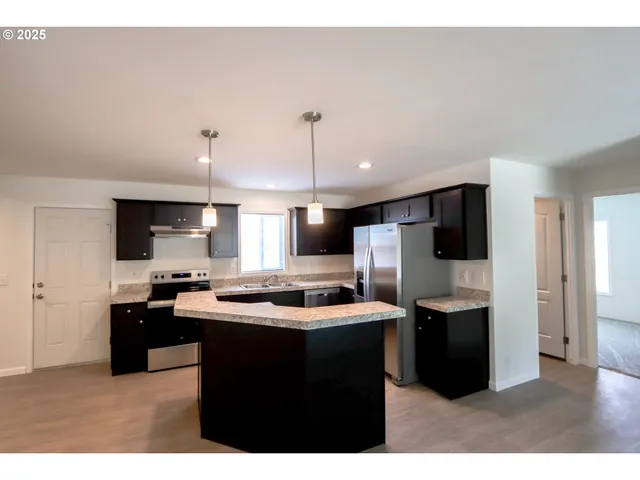 a kitchen with kitchen island a sink and stainless steel appliances