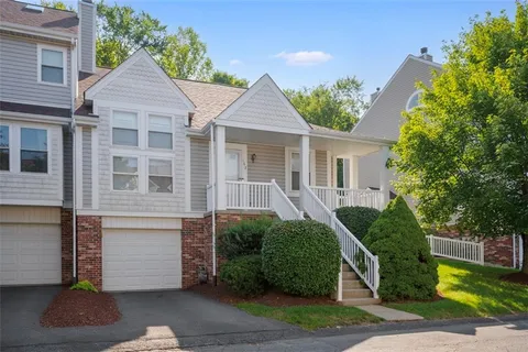 a front view of a house with a yard and potted plants
