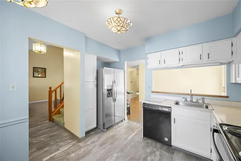 a view of a kitchen with refrigerator and cabinets
