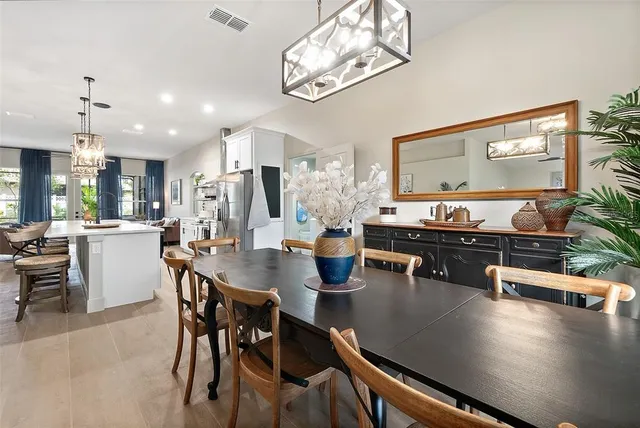 a view of a dining room and livingroom with furniture wooden floor a chandelier