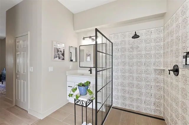 a bathroom with a granite countertop sink a mirror and a shower