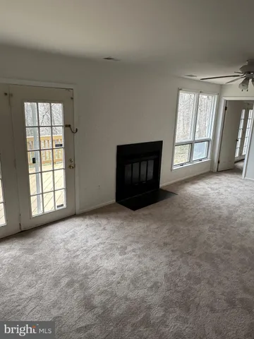 a view of an empty room with a fireplace and a window